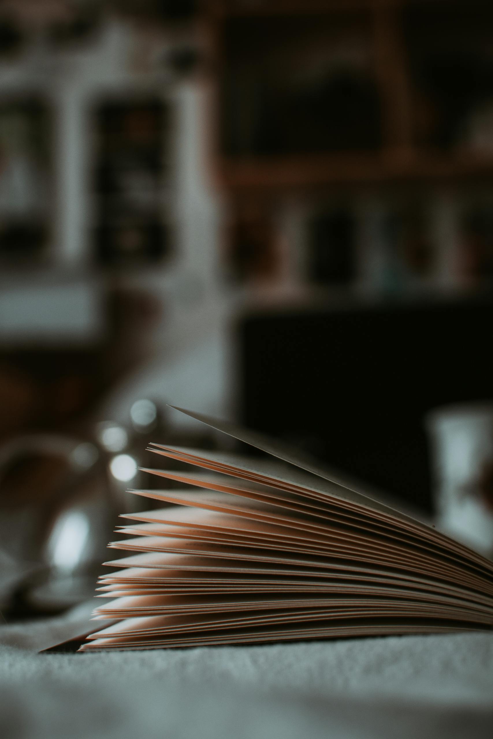 Artistic shot of an open book with a focus on pages, creating a cozy reading ambiance.