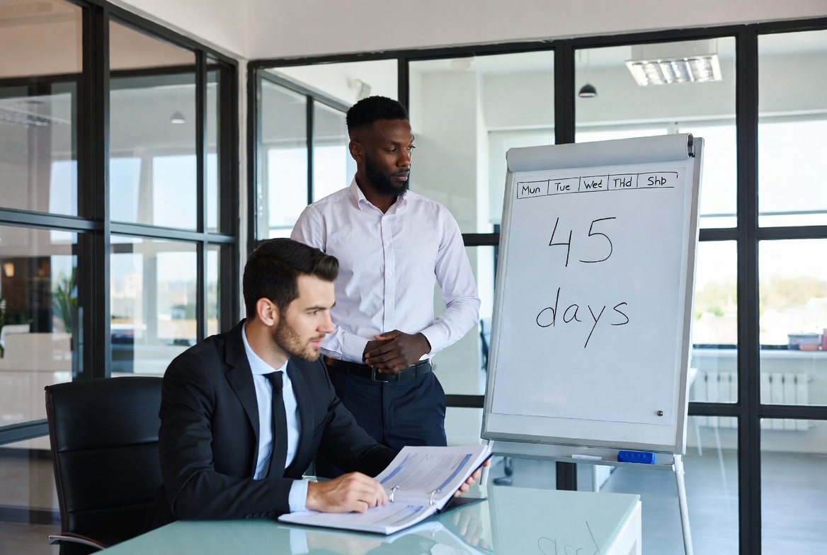 A real estate investor and a Qualified Intermediary mapping out a 45-day property identification timeline on a clean glass whiteboard
